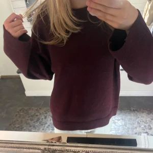 Vinröd stickad tröja - Säljer en mysig vinröd stickad tröja med långa ärmar och ribbade muddar. Perfekt för kyliga dagar och ger en stilren look. Använt nog 1 eller 2 gånger. Inte riktigt min stil💕