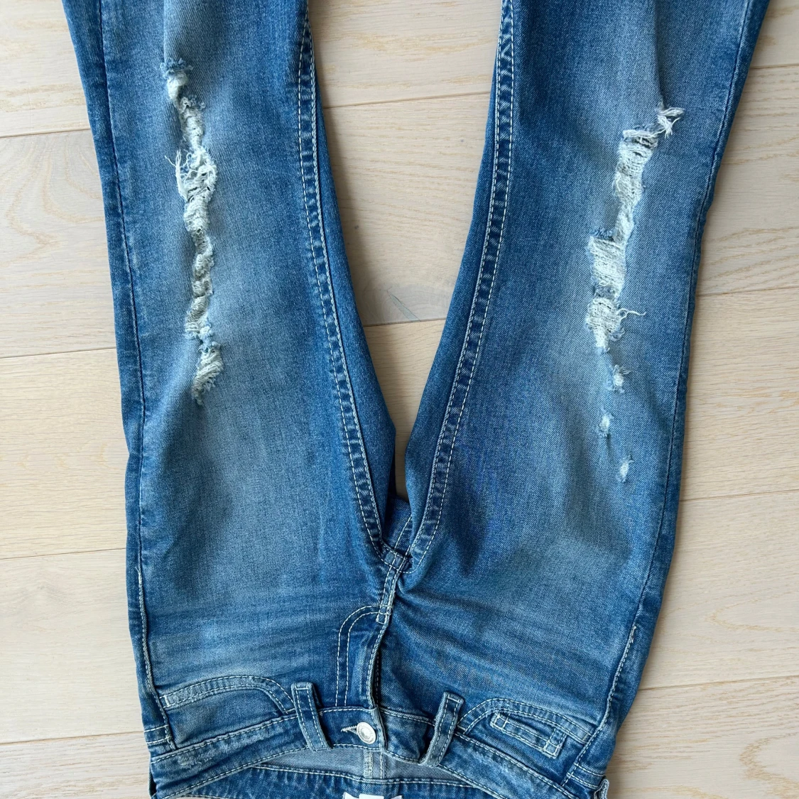 Blå bootcut jeans med slitningar