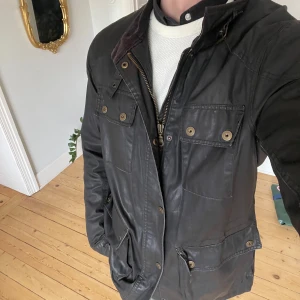 Svart field jacket - Riktigt häftig Barbour-liknande oljerock/safarijacka. Storlek L. Mycket fint skick