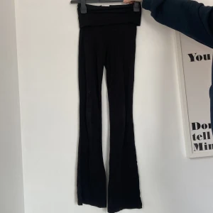 Svarta yoga pants från Gina Tricot - Snygga svarta byxor från Gina Tricot med låg midja och utsvängda ben. Perfekta för en stilren look. Byxorna är tillverkade i ett mjukt och bekvämt material som ger en skön passform. Priset kan diskuteras.