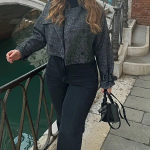 Grå rutig kavaj från Stradivarius - Säljer en snygg grå rutig kavaj från Stradivarius. Den är croppad med dubbelknäppning och har långa ärmar med knappar vid ärmsluten. Perfekt för en stilren look!