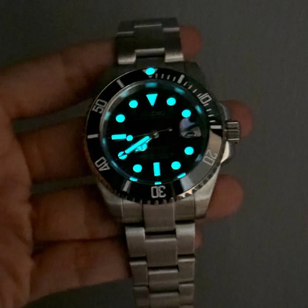 Nu är denna Svart Submariner-mod redo för försäljning! (Custom-made.) Diameter: 40 mm | Tjocklek: 12 mm | Seiko NH35 automatiskt urverk | Safirglas (reptåligt, AR-behandlat) | Boett & armband i 316L rostfritt stål (säkerhetslås) | Keramisk bezel | Skruvad krona | Luminova-beläggning | Vattentålighet: 3 ATM | Genomskinlig baksida | Justerbar storlek: 14,5–22 cm. Frågor? Skicka DM!. Asusteet.