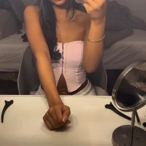 Rosa ribbad korsett - Säljer en söt rosa korsett med ribbad textur och dragkedja framtill. Perfekt för en stilren och trendig look. Passar bra till både jeans och kjol.