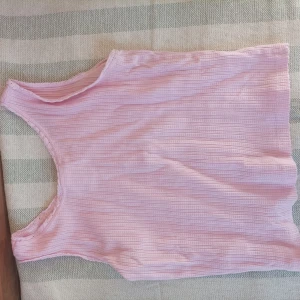 Rosa ribbad linnetopp från Zara - Säljer en söt rosa ribbad linnetopp från Zara. Toppen har knappar framtill och är ärmlös, perfekt för varma dagar. Den har en mjuk och bekväm passform.