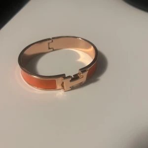 H armband  - Säljer mitt orangea och guldiga h armband för jag tröttnat på det. Obs defekt! Skriv för frågor och prisförslag. 