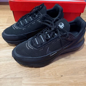 Svarta Nike Air Max Pulse sneakers - Snygga svarta Nike sneakers med snörning och en stilren design. Skorna har en rund tå och är tillverkade i syntetmaterial med en robust sula för bra grepp. Perfekta för både vardag och träning.