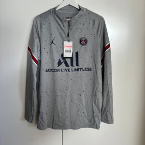 Grå långärmad fotbollströja från Jordan x PSG - Snygg grå långärmad fotbollströja från Jordan x PSG. Alldrig använd prislappen sitter fortfarande kvar på tröjan. 