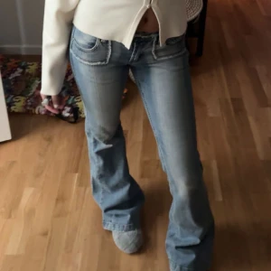 Blå bootcut jeans från Blue Queen - Säljer ett par snygga blå bootcut jeans från Blue Queen . De har en klassisk femficksdesign och en bekväm passform. Perfekta för en avslappnad stil. Men dragkedjan behöver fixas eftersom den åker ner lite           Midja 35cm och innebenlängd 85cm🤍