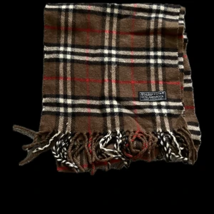 Burberry Halsduk - En klassisk burberry halsduk med stilrent mönster. Från 1999-2000 talet. Mitt pris är 200kr. Skriv i dm innan köp!