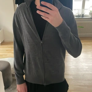 These glory days tröja - Säljer en stilren grå kofta med dragkedja. Perfekt för lager-på-lager och har långa ärmar med ribbade muddar. Passar bra till både vardag och avslappnade tillfällen.