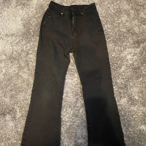 Svarta jeans med broderade fickor - Snygga svarta jeans med broderade detaljer på bakfickorna. De har en klassisk femficksdesign och stängs med dragkedja och knapp. Perfekta för en stilren look.