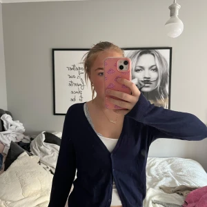 Mörkblå kofta - Säljer en stilren mörkblå kofta med knappar framtill. Perfekt för lager-på-lager och passar till många olika outfits.