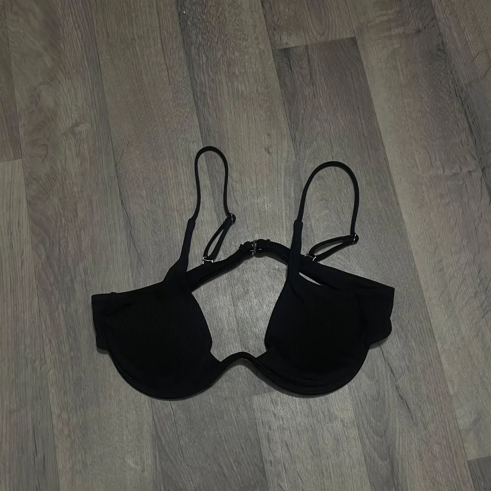 Snygg svart Calvin Clein bikiniöverdel med justerbara axelband och en stilren design. Den har en ribbad textur som ger en extra touch av elegans. Perfekt för en dag på stranden eller vid poolen. Köpt för 649 från Calvin Clein. Muu.