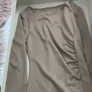 Beige blues från Shein - Säljer en stilren beige bluse från Shein med långärmad design och en elegant drapering på sidan. Perfekt för en chic look. 💫använd bara 1 GÅNG