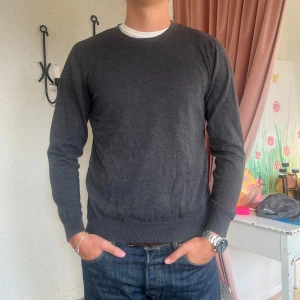 Mörkgrå tröja - Säljer en stilren mörkgrå tröja med rund halsringning. Sann i storlek.