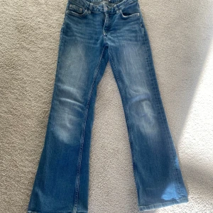 Blå jeans med bootcut - Snygga blå jeans med bootcut, Perfekta för en avslappnad look. Klassisk femficksdesign och knappgylf. De går inte att köpa längre i butik. Säljer pga att dem är för små för mig 🙌🏻 skriv gärna vid intresse!