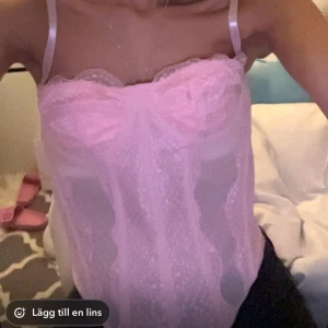 Rosa spetskorsett - Säljer en söt rosa korsett med spetsdetaljer och justerbara axelband. toppen kan regleras med band väldigt bra och har en genomskinlig design som ger en romantisk look. går att ha utan bh. postar direkt vid köp. Perfekt till sabrina carpenter!!💓💘💕💕🎀