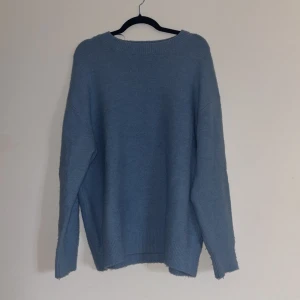 Blå stickad oversized tröja från Zara - Mysig blå stickad oversized tröja från Zara med rund halsringning och långa ärmar. Perfekt för kyligare dagar och enkel att matcha med olika outfits. Tröjan har en klassisk design med ribbade kanter. Använd fåtal gånger