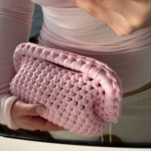 Rosa handvirkad clutch/handväska - Säljer en rosa handvirkad clutch / handväska. Väskan är i ett mjukt garn och är väldigt rymlig! Kan bäras i handen som en clutch eller bäras i handtaget.  Kan Även Göra Andra Färger / storlekar💕