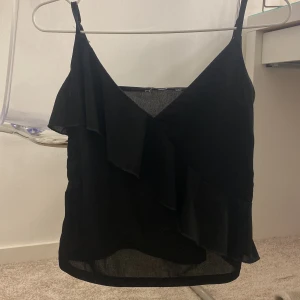 Svart topp med volang - Super fin volang topp från HM som inte säljs längre. Toppen är i storlek S och är använd ca 3 gånger. Ganska luftigt material som är perfekt till sommaren💕