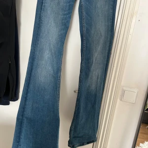 Blå jeans från Zara - Snygga blå jeans från Zara med en klassisk femficksdesign. De har en rak passform/bootcut och är tillverkade i ett slitstarkt denimtyg. Perfekta för en avslappnad stil.