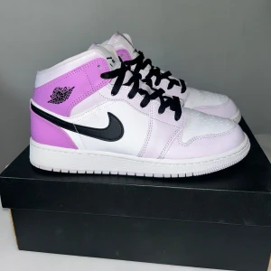 Air Jordan 1 Mid - Barely Grape - Snygga Air Jordan 1 Mid i färgen Barely Grape. Skorna har en stilren design med en kombination av lila och vit, samt svarta detaljer och snörning. Perfekta för dig som vill ha en unik och trendig look. Storlek 40 men passar 39 jag har mindre 39 men i jordans vill du ha en storlek större:) är öppen för bud!