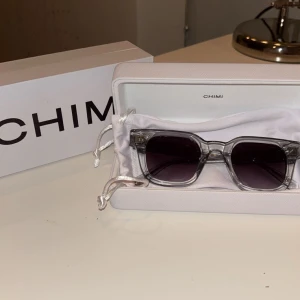 Chimi 04 gråa - Säljer ett par Chimi 04 i grå som är perfekta till solen och för en fräsch look‼️Jag säljer dem eftersom de inte kommer till användning dem är inprincip helt nya. Allt på bild och ingår. Tveka inte om att ställa några frågor