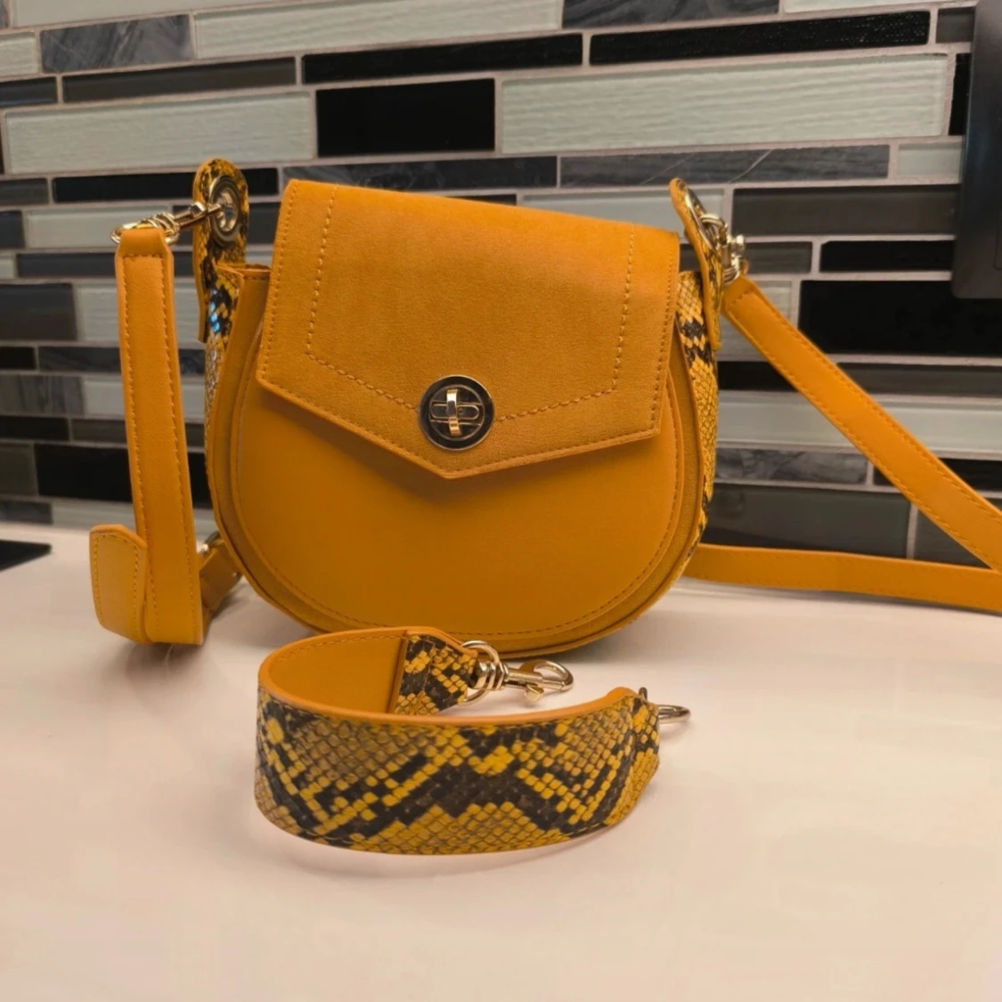 Gul axelväska med ormmönstrade detaljer
