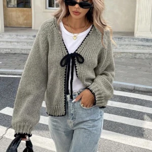 Grå stickad kofta med svart knytband - Superfin grå stickad kofta med svarta detaljer och knytband framtill. Köpte nyligen men är för liten. Säljer i storlek M men passar även en S. Pris kan alltid diskuteras 🫶🏼