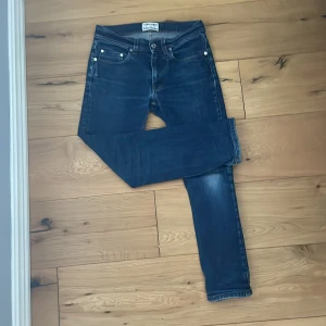 Mörkblå jeans från Acne Studios 28/32 - Snygga mörkblå jeans från Acne Studios i modellen Ace STR RW. Klassisk femficksdesign, raka ben och normal passform. Tillverkade i bomull med lite stretch för extra komfort. Perfekta till sneakers eller boots.