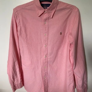 Ralph Lauren skjorta - Snygg rosa skjorta från Ralph Lauren i slim fit-modell. Skjortan har storlek M men sitter mer som en S eftersom det just är en slim fit modell. Skjortan är gjord av bomull och den är riktigt fräsch nu inför sommaren🌟
