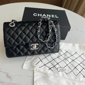 Svart Chanel väska - Superfin svart Chanel väska i svart läder med silvriga detaljer. Box dustbag ingår 💕