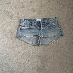 Blå jeansshorts från Pull&Bear - Snygga ljusblå jeansshorts från Pull&Bear med råa, fransiga kanter och slitna detaljer. Den har aldrig varit använd, säljer den pga att den är för liten. Kan tyvärr inte skicka bild på den på mig för att jag inte får på mig den.skriv om du har frågor 💗