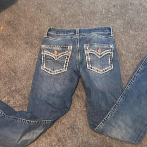 Blå jeans med kontrastsömmar Gina Tricot - Snygga blå jeans från Gina Tricot i storlek 158. Jeansen har markerade vita kontrastsömmar och coola ficklock med knapp bak. Klassisk femficksmodell och normal passform. Perfekta för dig som vill sticka ut lite extra med detaljer.