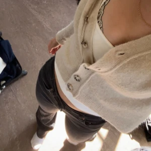 Beige kofta  - Superfin beige kofta i croppad modell med stora knappar framtill. Mjuk och mysig känsla, perfekt att slänga över ett linne eller topp. Långärmad och passar grymt till både jeans och kjol.