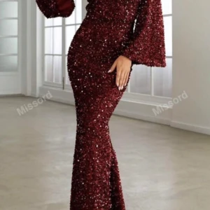Vinröd glittrig långklänning Missord - Supersnygg vinröd långklänning från Missord med glittriga paljetter över hela klänningen. Den har långa utsvängda ärmar och figurnära passform som framhäver siluetten. Perfekt för dig som vill sticka ut på bal eller fest!