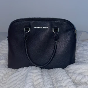Svart handväska från Michael Kors - Jättefin svart väska från Michael kors❤️är lite sönder i handtaget men den funkar som vanligt att använda 👩‍❤️‍💋‍👩 kan diskutera pris 