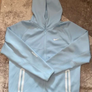 Babyblue Nike Nocta tech fleece - En riktigt fet babyblå Nike Nocta tech fleece använd endast ett fåtal par gånger. Riktigt bra skick oxh storlek XL, skriv vid frågor ☺️🤝