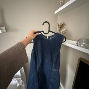 Jeansklänning Zara!🩷 - Ärmlös jeansklänning i mörkblå denim med rund halsringning och markerade sömmar. Klänningen har en rak passform och stängs med dragkedja bak. Endast använd en gång!🩷