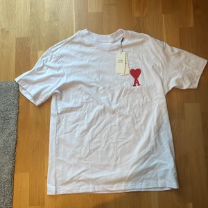 Ami paris t shirt - Säljer denna ritkigt feta ami paris t shirten i vit färg med rött hjärta, ritkigt snygg till sommaren!