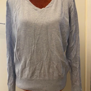 Ljusblå v-ringad tröja från H&M L - Ljusblå stickad tröja med V-ringning och långa ärmar. Ribbstickning vid halsringningen, ärmslut och nederkant. ﻿87% bomull, 17% polyamid ﻿Längd: 64 cm, byst: 97 cm