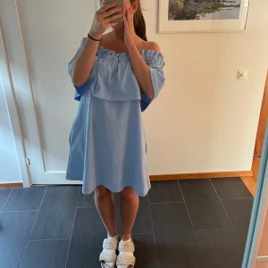 Ljusblå offshoulder klänning - Superfin ljusblå kortklänning med offshoulder och volang upptill!! 
