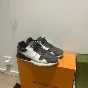 Louis Vuitton sneakers svart/vit skinn - Exklusiva Louis Vuitton sneakers i svart och vitt skinn med klassiskt LV-monogram över hela skon. Snygg och modern design med rund tå, snörning och platt sula. Perfekta för dig som vill sticka ut med lyxiga detaljer och premiumkänsla.