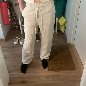 Beiga linnebyxor med snörning - Säljer ett par beiga linnebyxor som är jättesnygga till sommaren. Från H&M i storlek Xs. Vid benen är det uppsprättat.  Säljer då de tyvärr har blivit för korta!