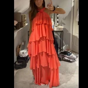 Lång  volangklänning - Superfin volangklänning från Vero Moda. Använd 1 gång på min studentskiva, den har inga defekter och ser som ny ut! Färgen är coral