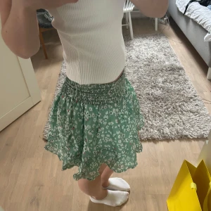 Blommig By malina kjol  - Supersöt grön kortkjol med vitt blommönster och små röda detaljer, kjolen är från By Malina💚