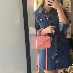 Jeansklänning Zara - Snygg mörkblå jeansklänning från Zara med knappar framtill, långa ärmar och bälte i midjan. Klassisk skjortkrage och två bröstfickor med lock. Perfekt för dig som gillar en cool och avslappnad stil.