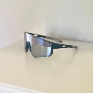 Sportiga svarta barn solglasögon  - Säljer ett par riktigt snygga barn sportglasögon med svart båge och stora spegelblanka linser. De har en futuristisk, kantig design och passar perfekt för dig som gillar att sticka ut när du tränar eller cyklar💪Lätta och bekväma att bära under långa pass😎