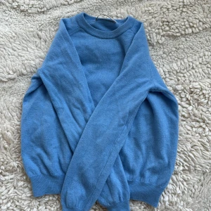 Blå stickad tröja från Zara - En enkel och stilren blå stickad casimir tröja från Zara. Tröjan har rund halsringning, långa ärmar och ribbade muddar vid ärmslut.  Den för för liten för mig!!