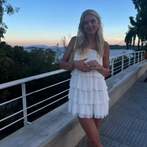 Vit volangklänning - Superfin vit kortklänning med volanger. lager volanger och plisserat tyg. Endast använd två gånger! 